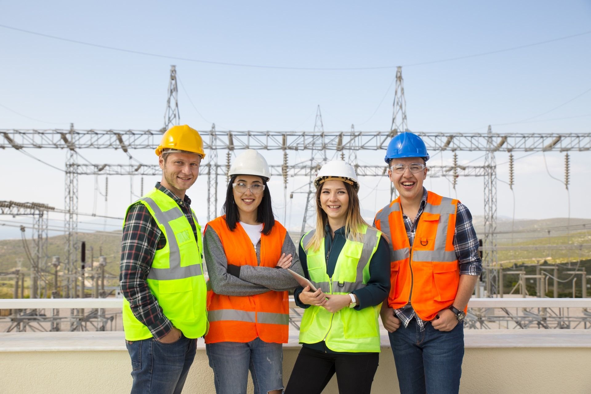 A group of construction workers are standing next to each other in front of a power station.