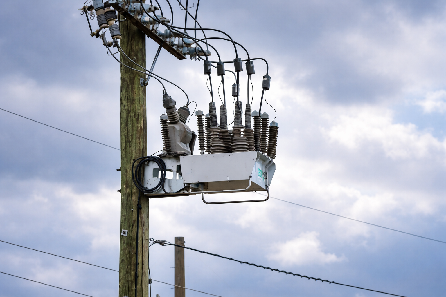 Automatic circuit recloser on distribution pole – sequence of reclosing shots for temporary fault restoration, coordination with upstream breaker and downstream sectionalizer.