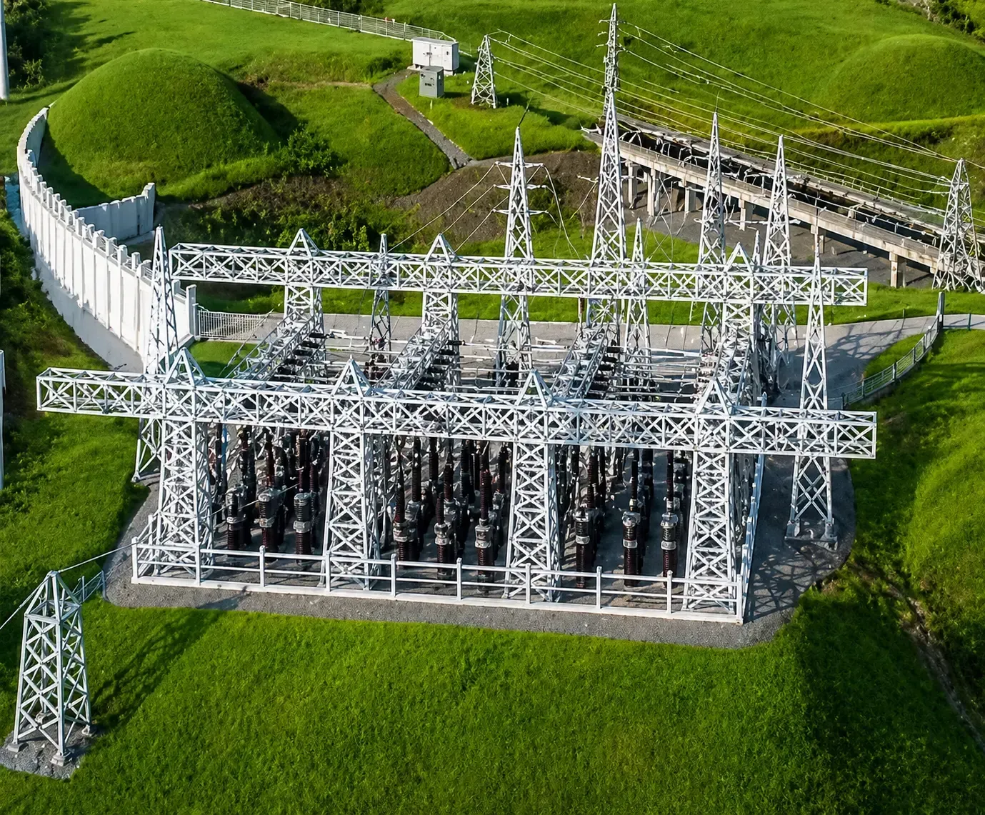 Solar panels in foreground, power lines and sunset in background.