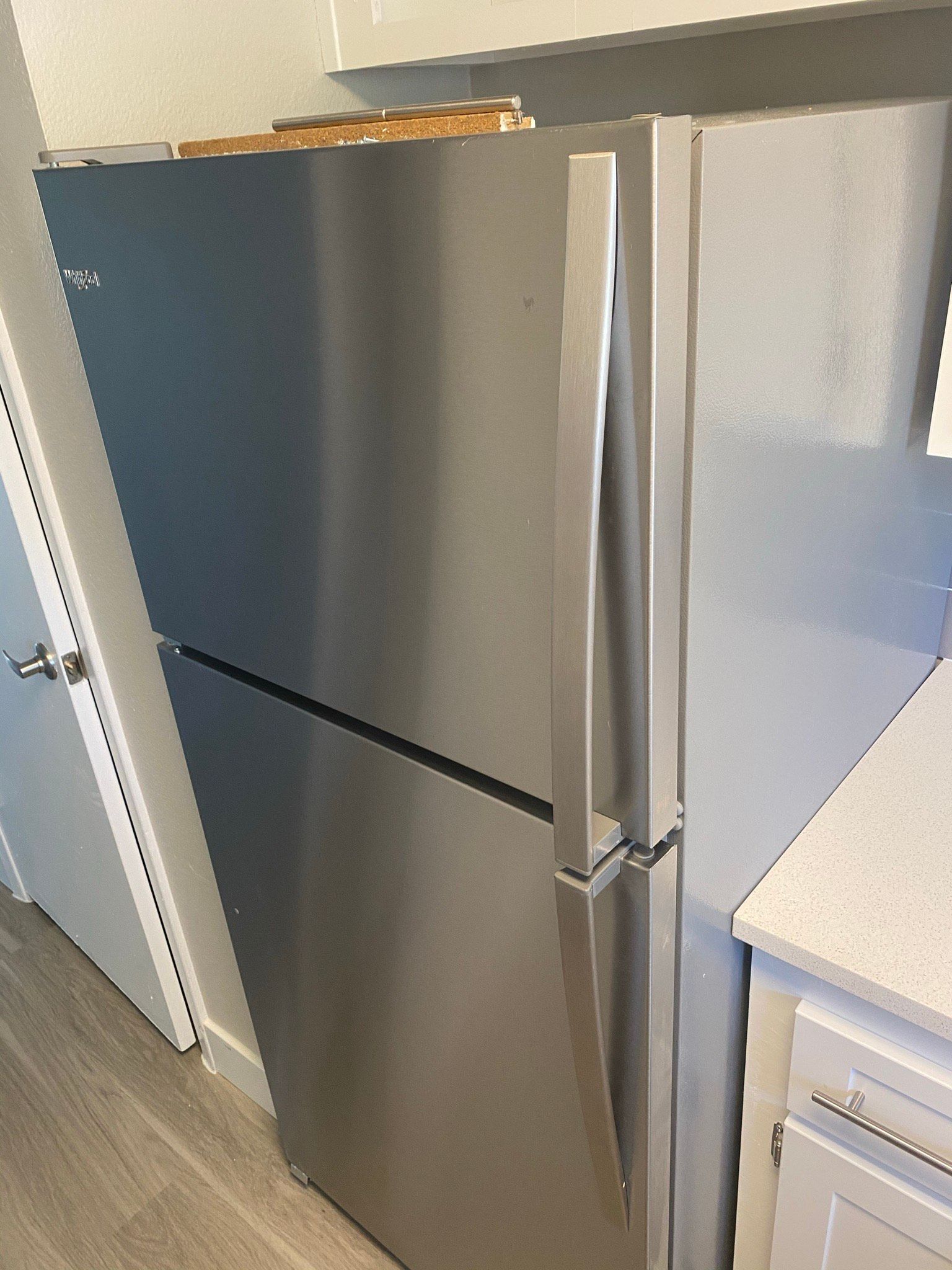a stainless steel refrigerator is sitting in a kitchen next to a counter . | Litchfield Park, AZ | Cleaning Elite