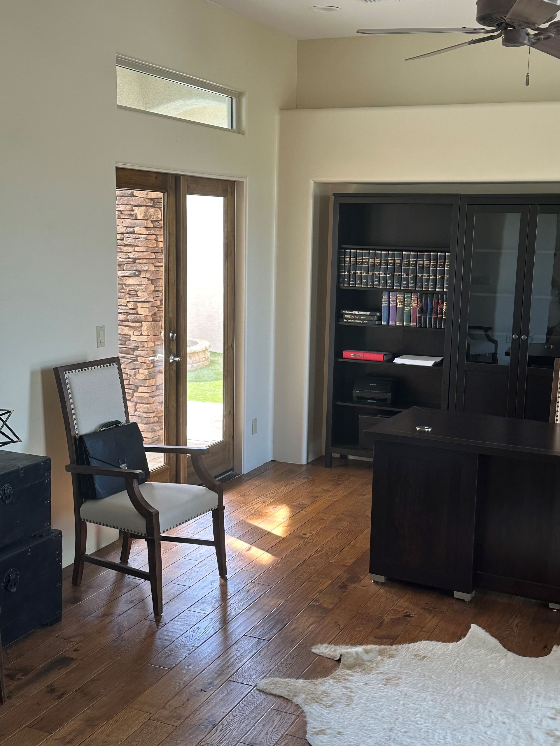 a living room with hardwood floors , a chair , a desk and a ceiling fan . | Litchfield Park, AZ | Cleaning Elite