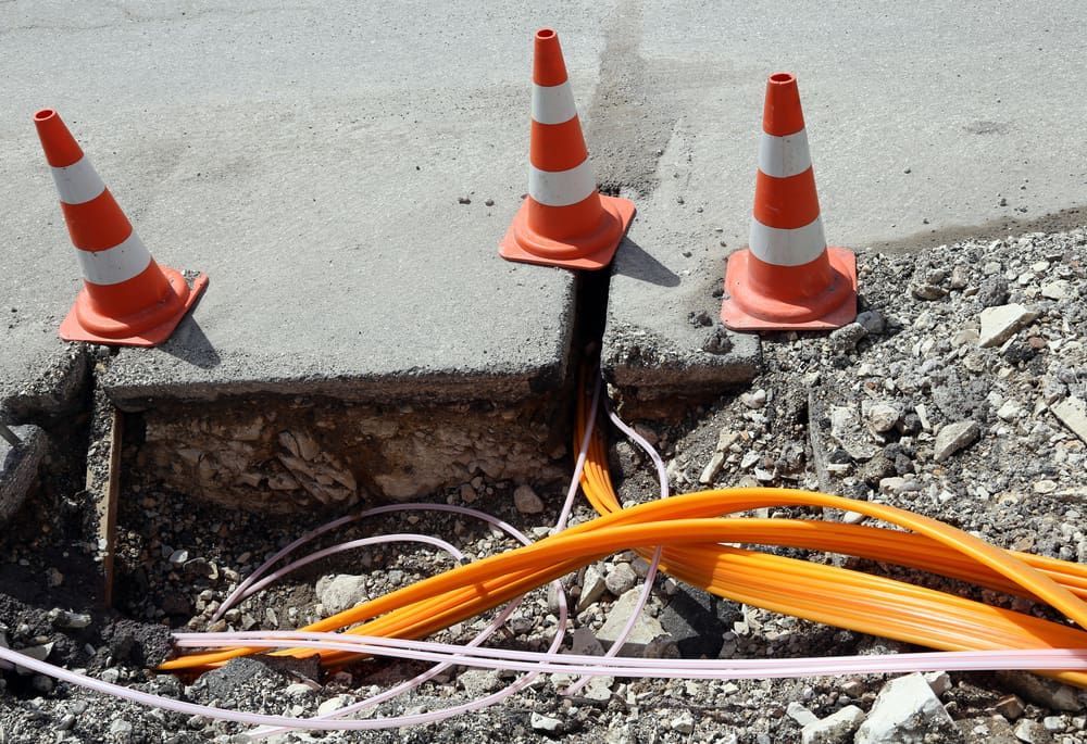 Three Orange And White Traffic Cones Are Sitting On The Ground — CQ Service Locating In Moranbah, QLD