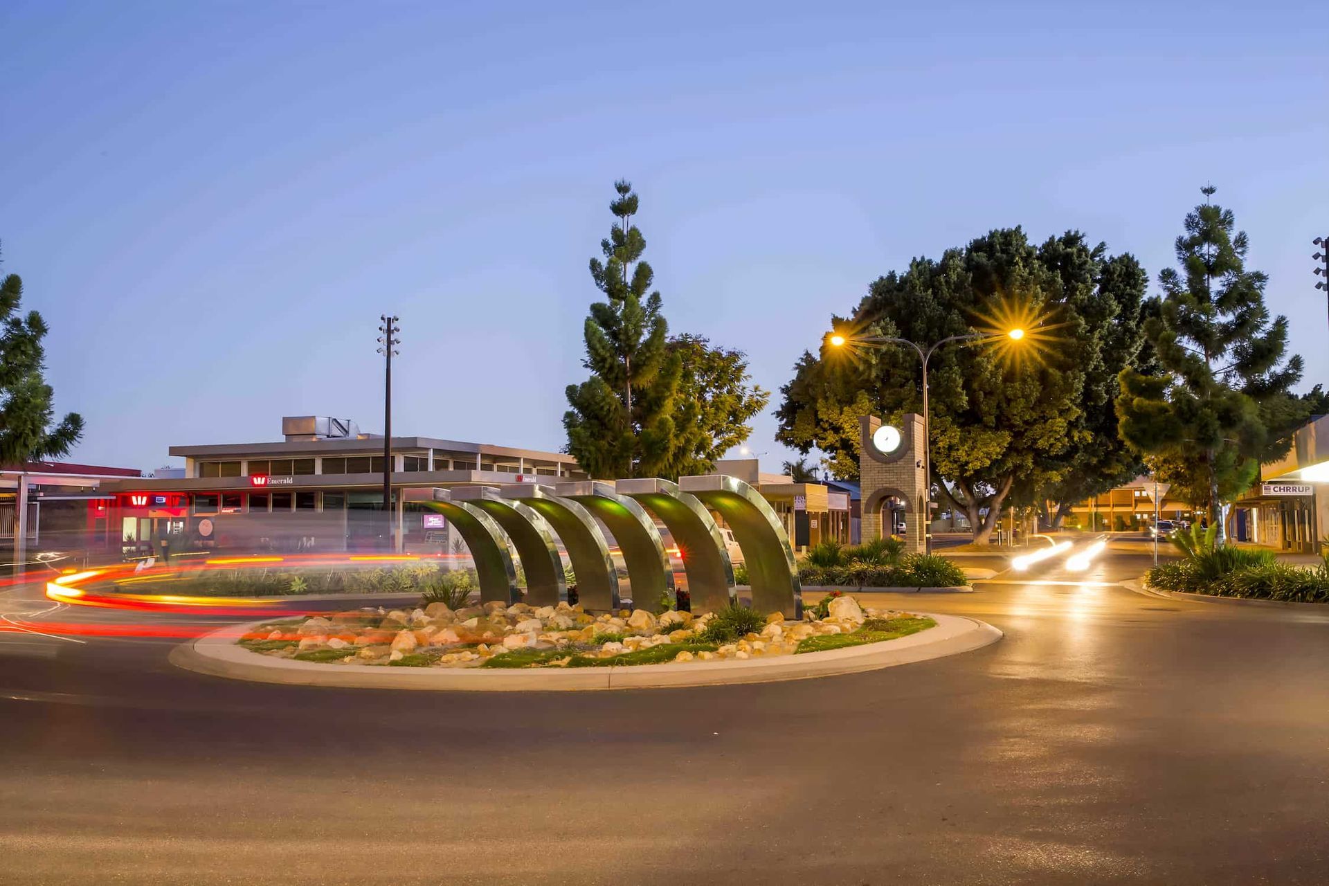 A Roundabout In A City At Night With A Clock Tower In The Background — CQ Service Locating In Emerald, QLD