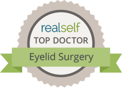 Realself Top Doctor badge for Eyelid Surgery; gray, green, and white.