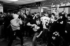 A black and white photo of a group of people dancing in a room.