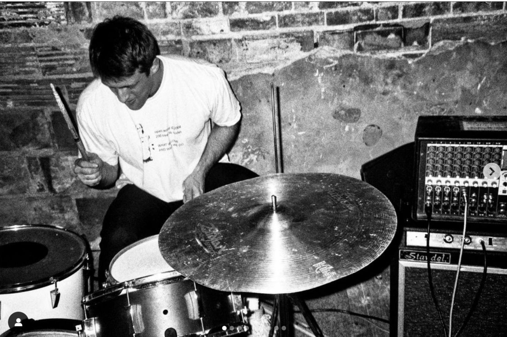 A man is playing drums in a black and white photo