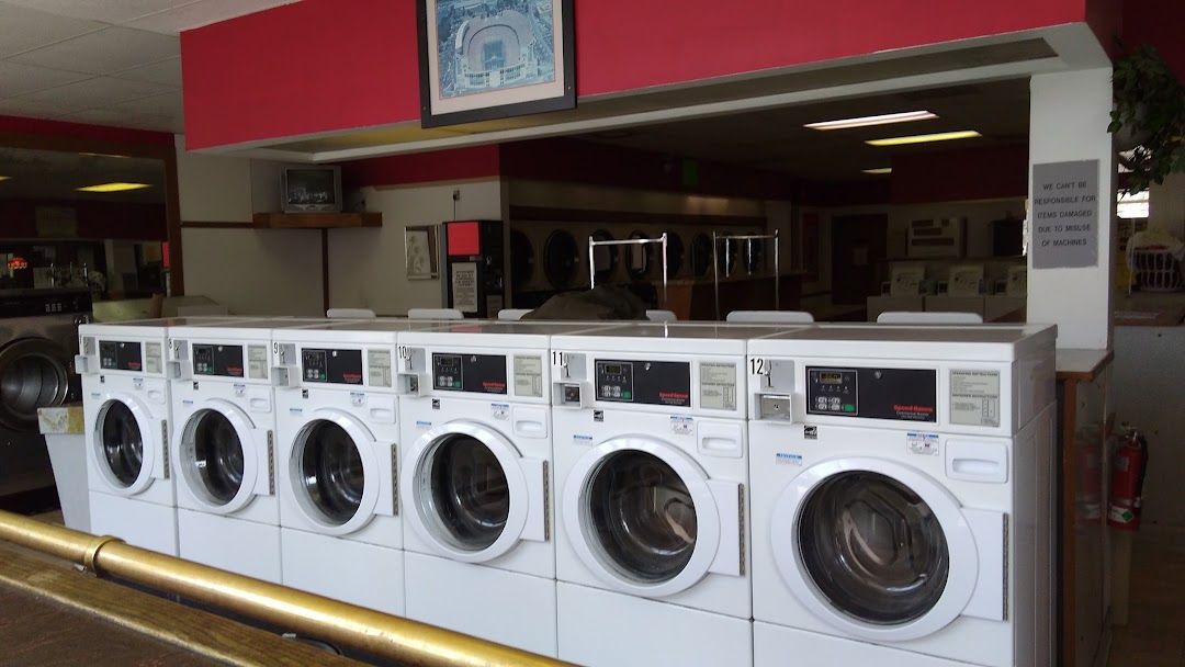 A row of washing machines are lined up in a laundromat.