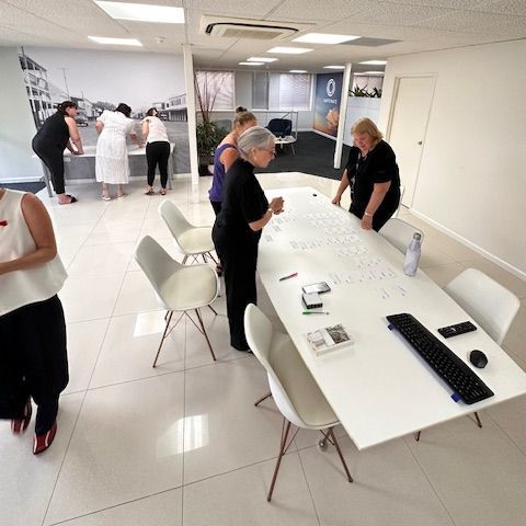 A group of people standing around a table with a keyboard on it