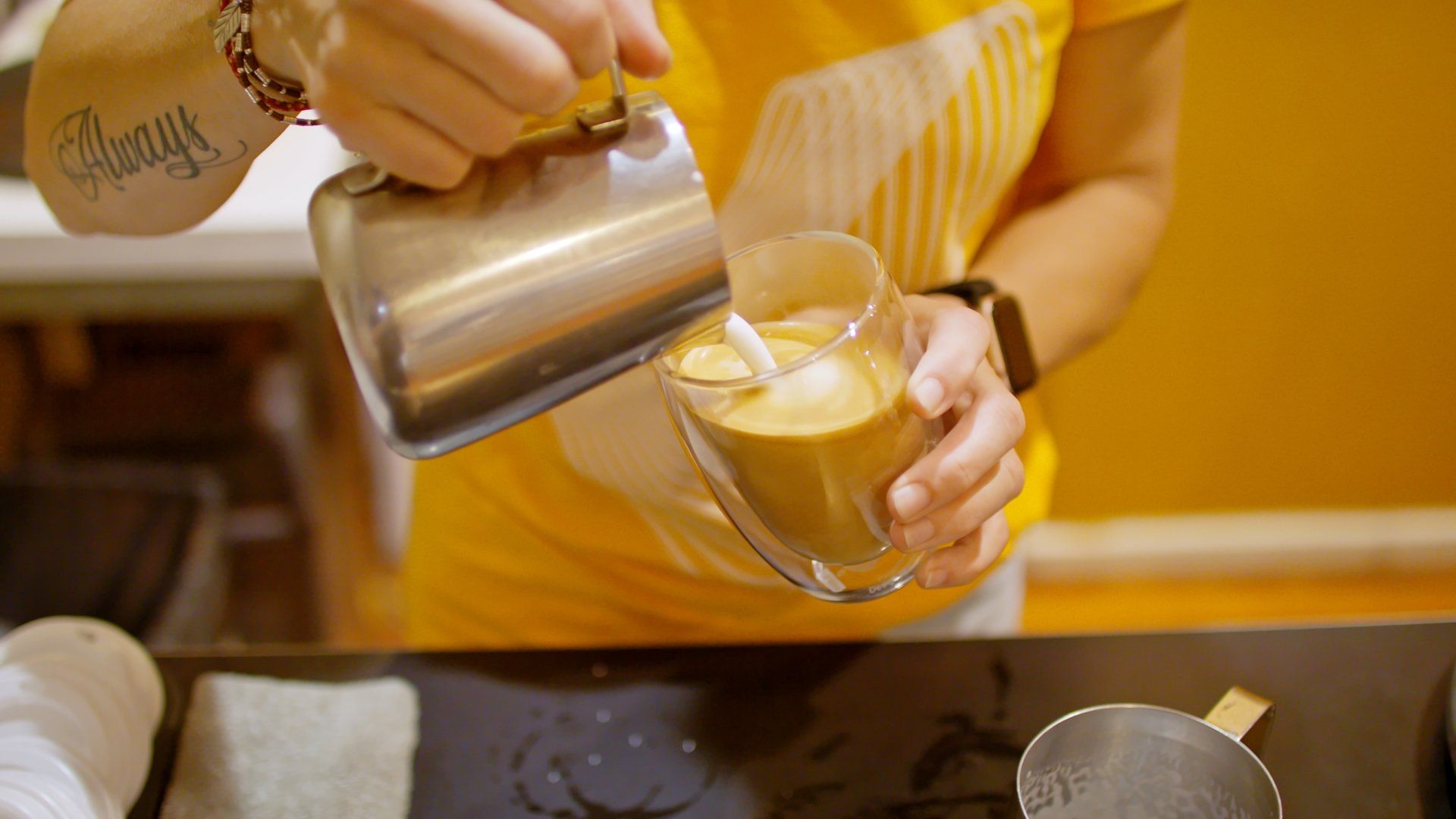 A person is pouring a cup of coffee into a glass.