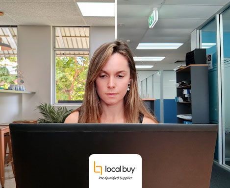 A woman is sitting in front of a laptop computer in an office.