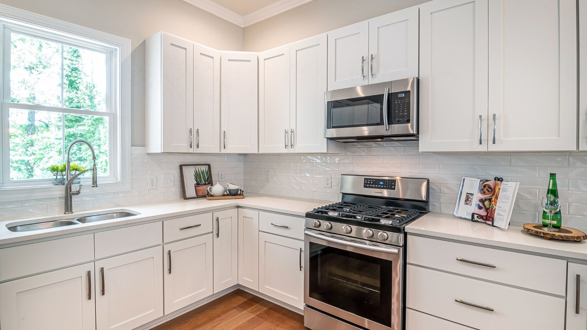 White kitchen with stainless steel appliances and white cabinets.
