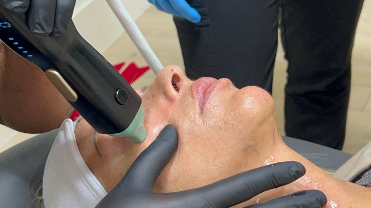 A woman is getting a facial treatment with a machine.