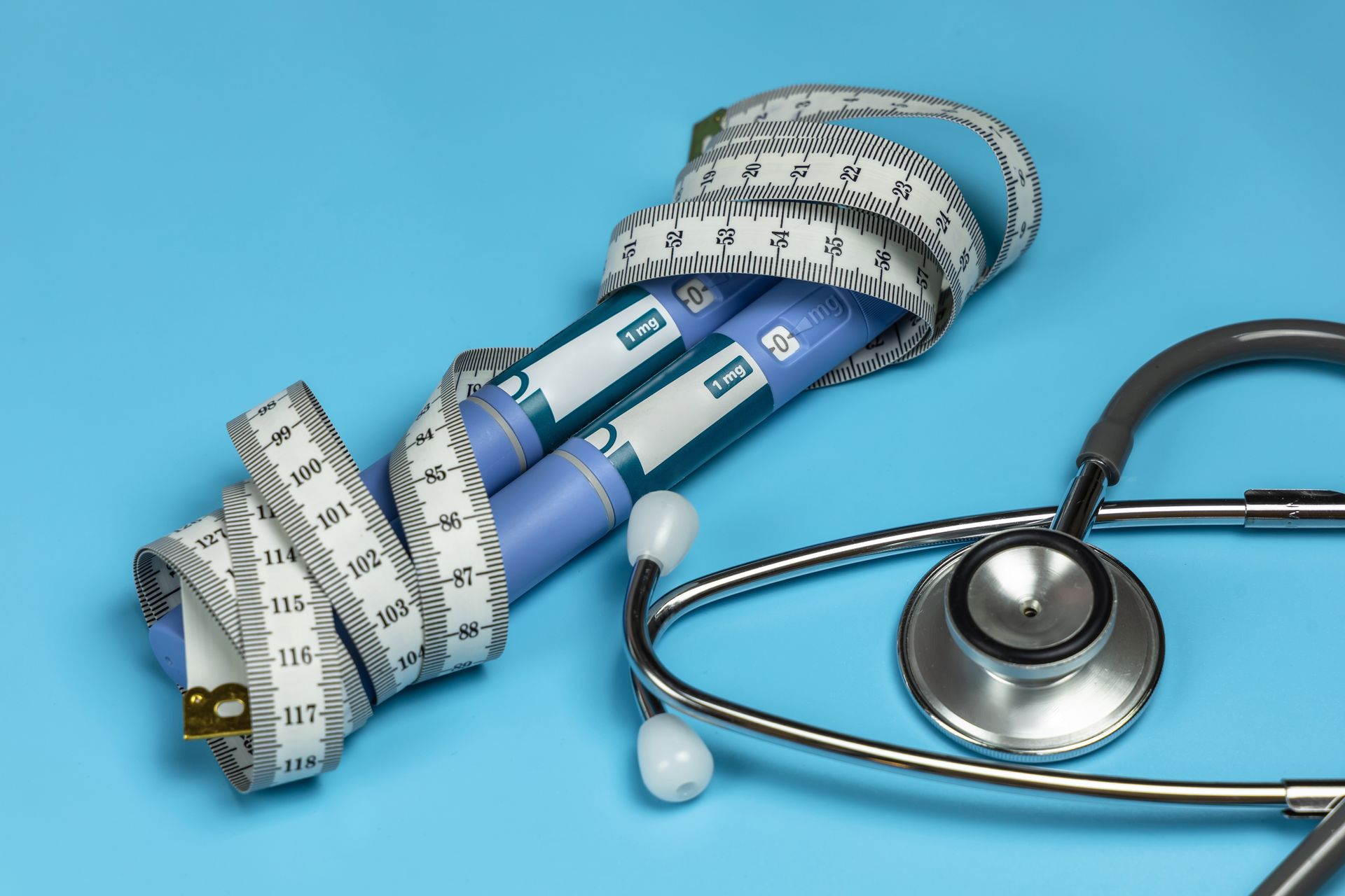 A stethoscope and a measuring tape on a blue background