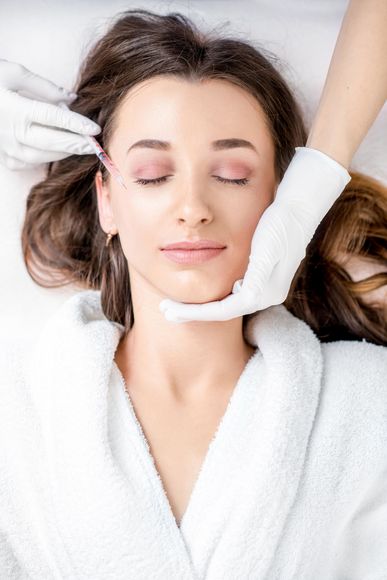 a woman is getting a botox injection in her face .