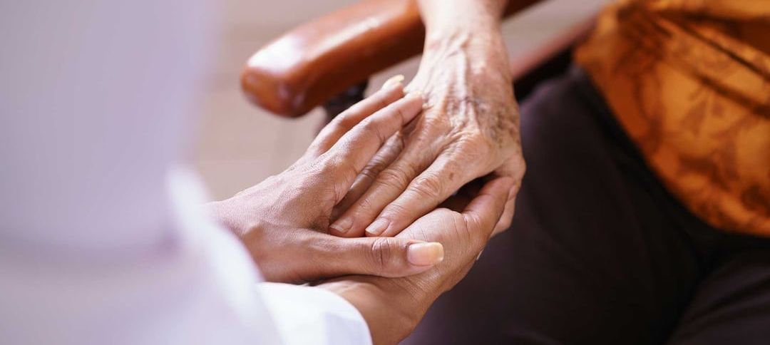 A close up of a person holding another person 's hand.