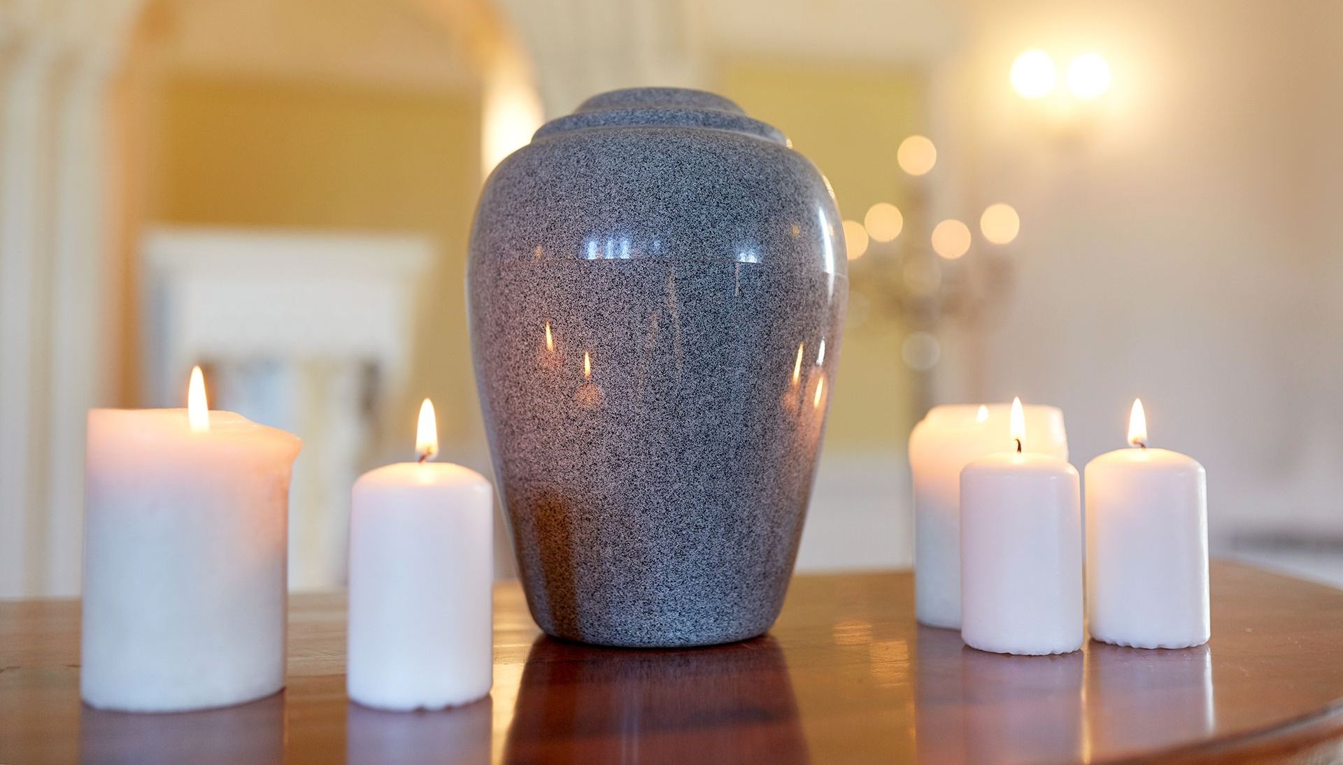 A vase sitting on top of a wooden table next to candles.