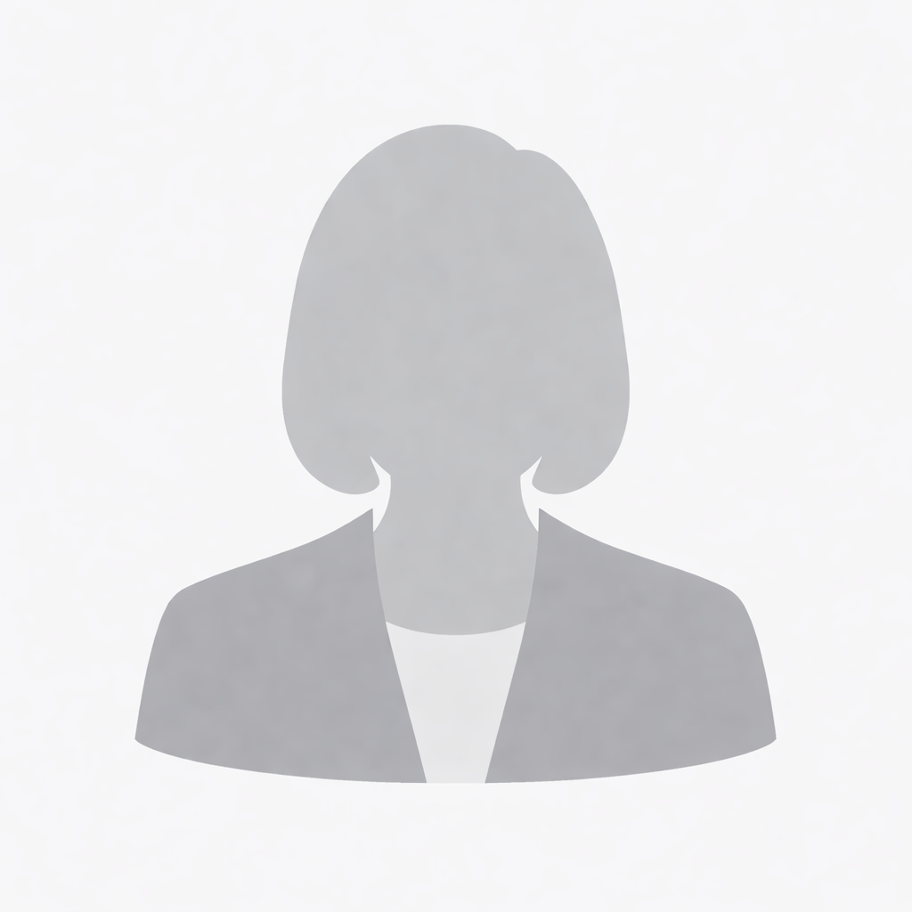 Man in green polo stands on a football field, arms crossed, stadium in background.