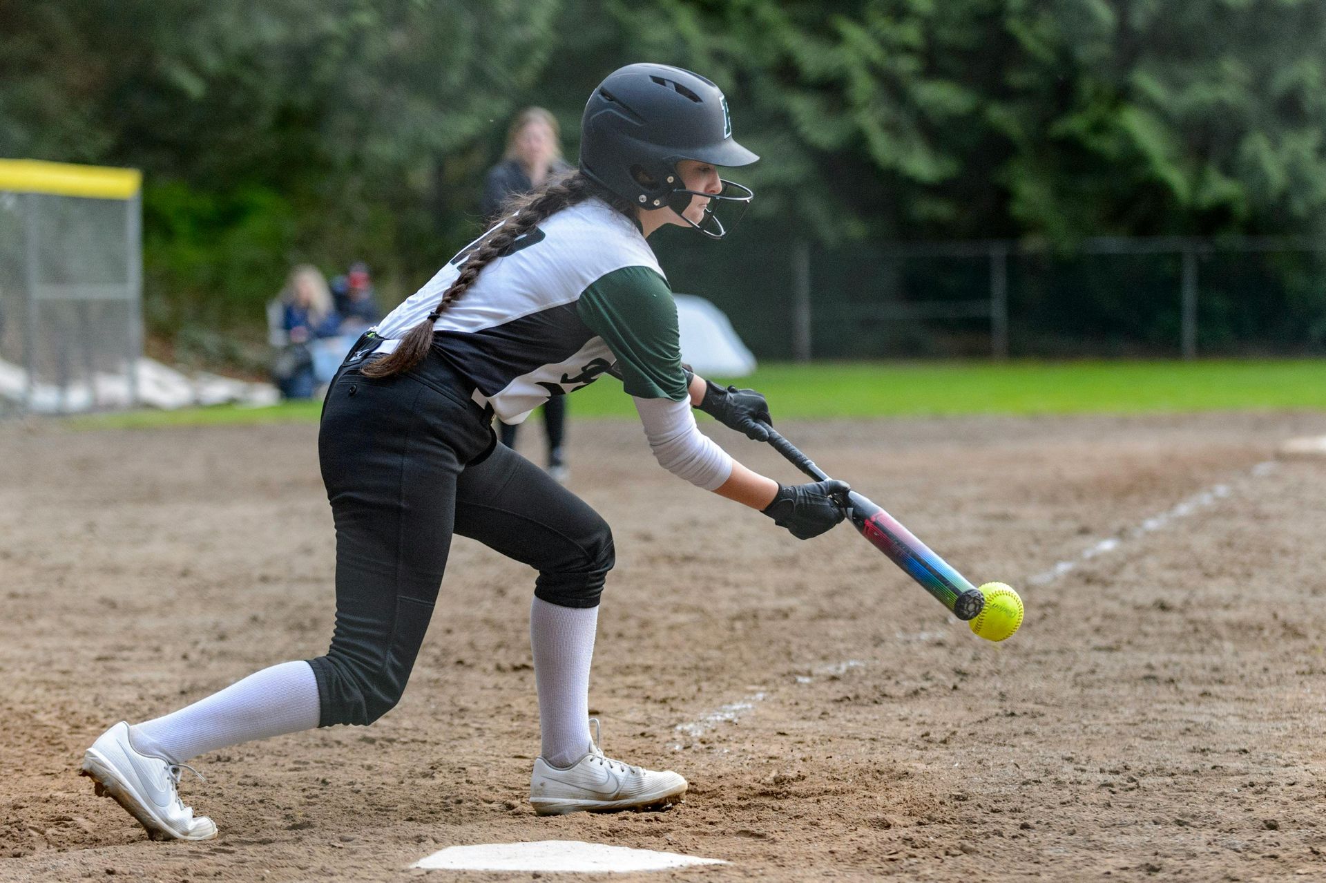 Baseball player sliding into base as another player attempts to catch the ball.