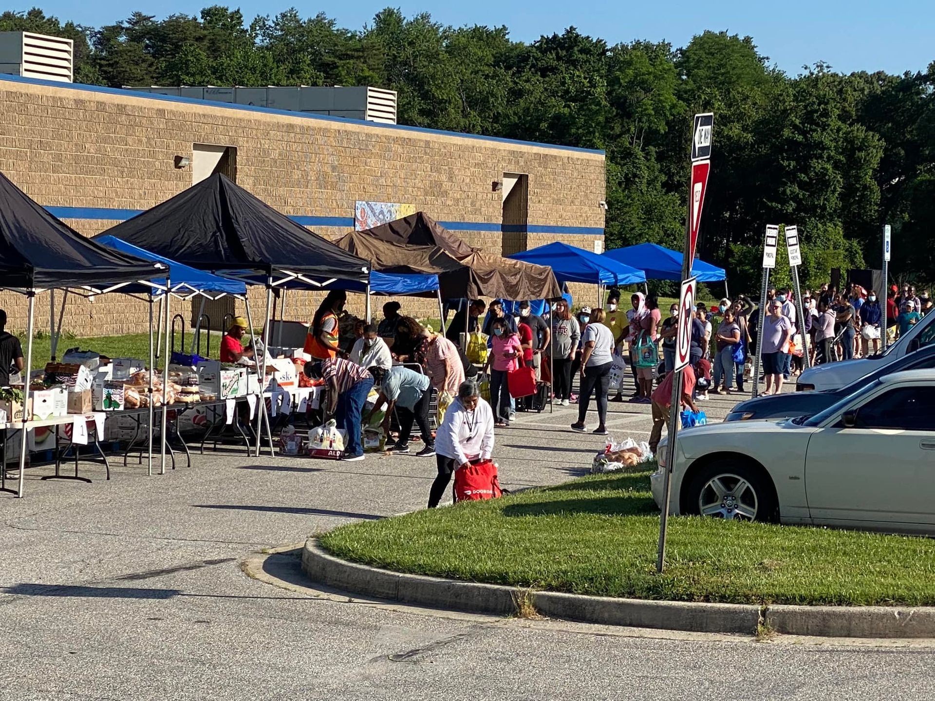 A large group of people are gathered in a parking lot.