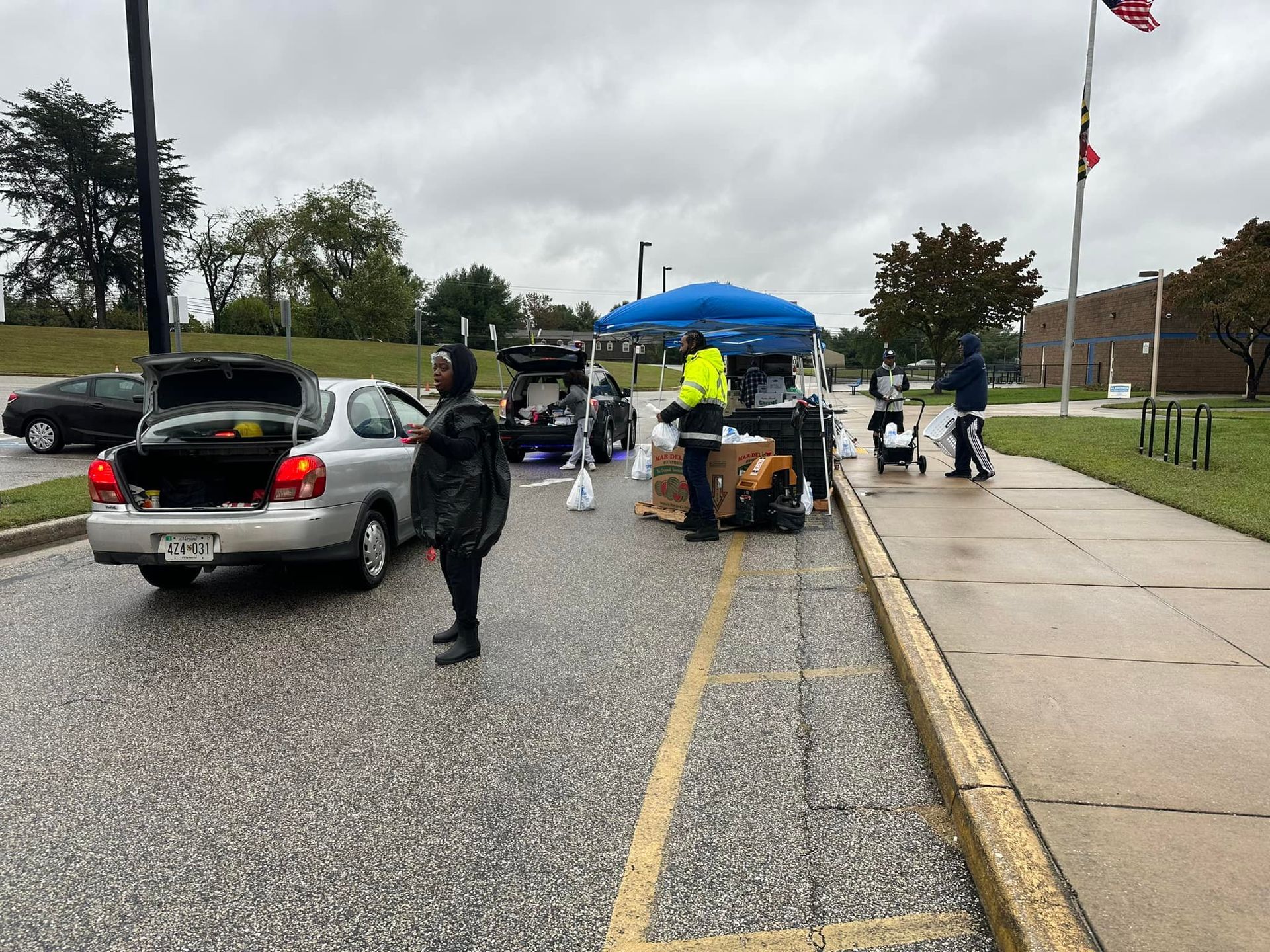 A man is standing next to a car on the side of the road.