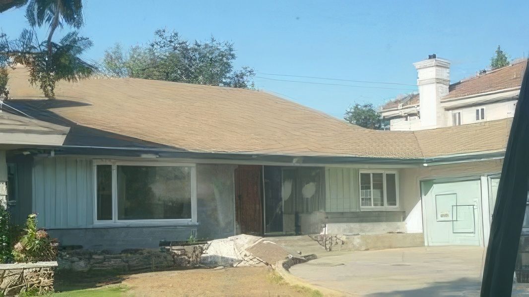 A house with a brown roof and a blue garage