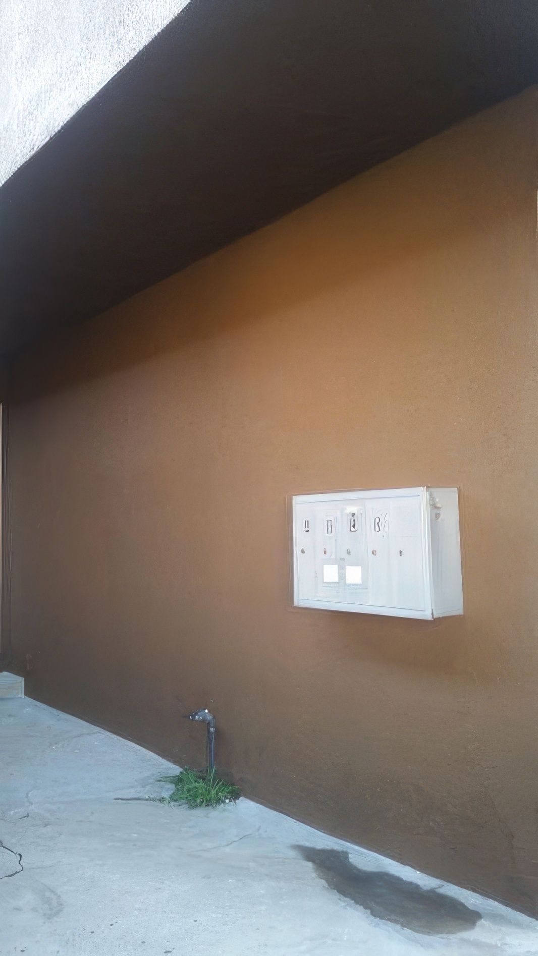 A brown wall with a white box on it.
