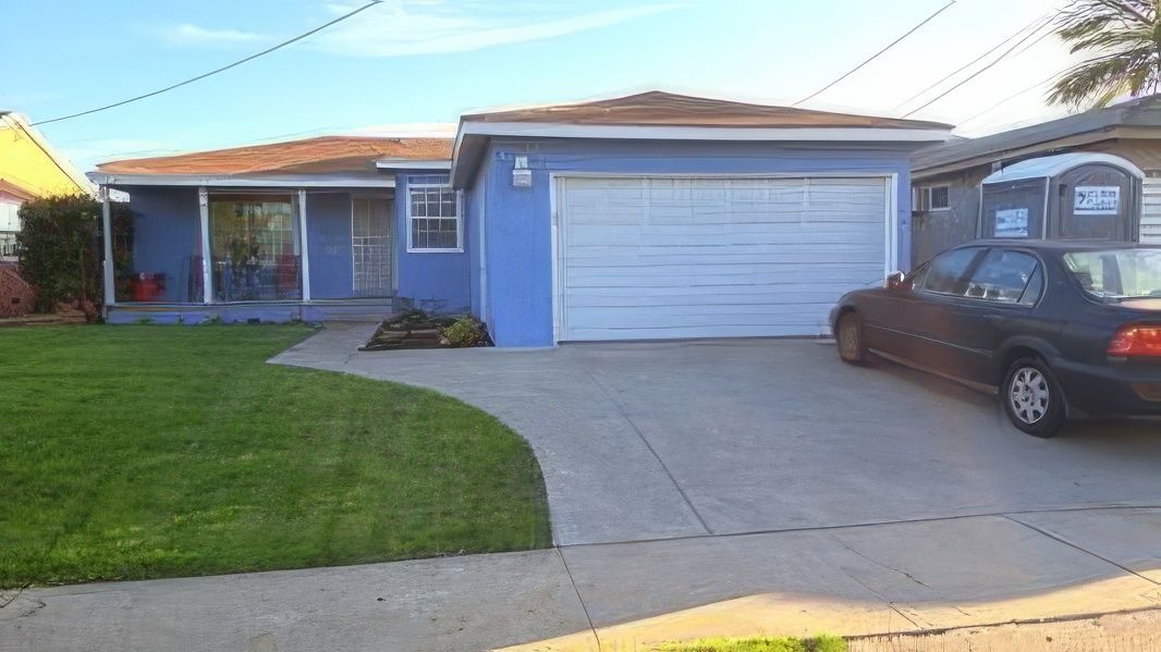 A blue house with a car parked in front of it.