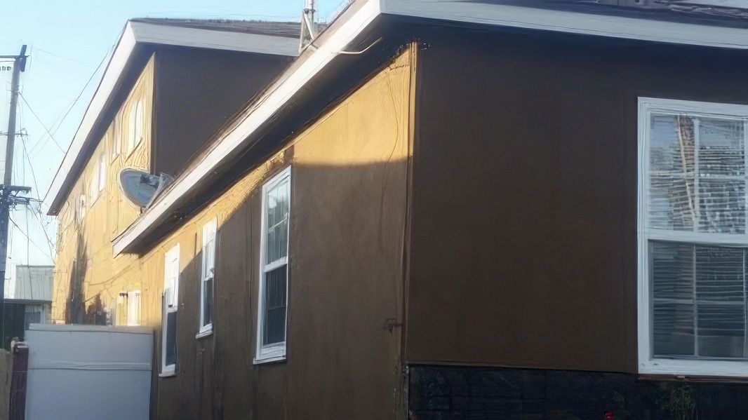 A house with a lot of windows and a satellite dish on the roof.