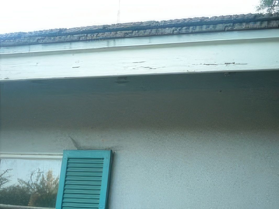 A white house with blue shutters on the window