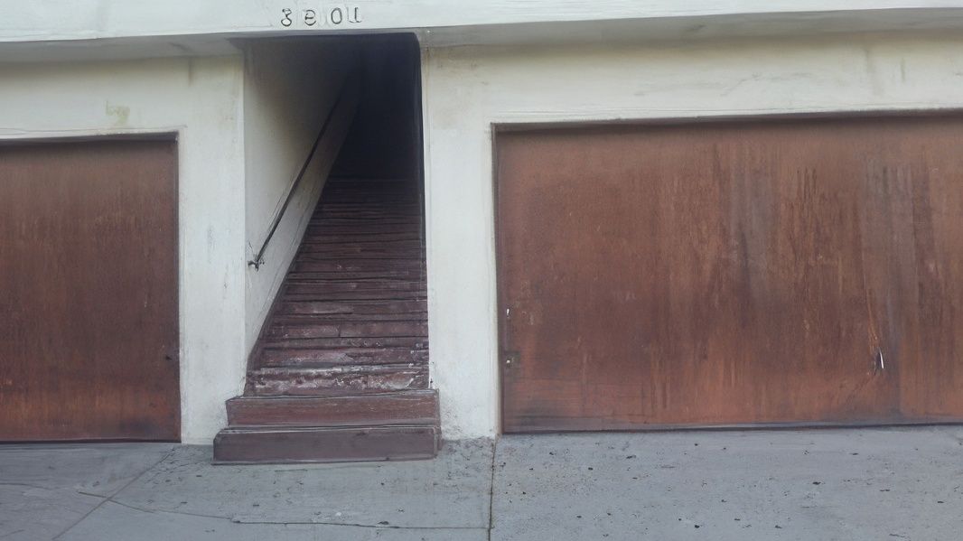 A set of stairs leading up to a garage door.