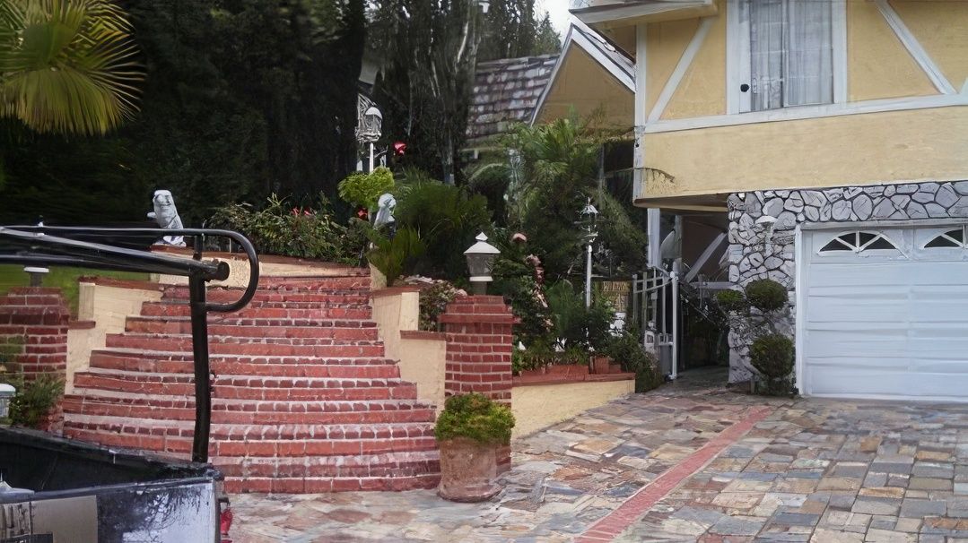 A house with stairs leading up to it and a white garage door