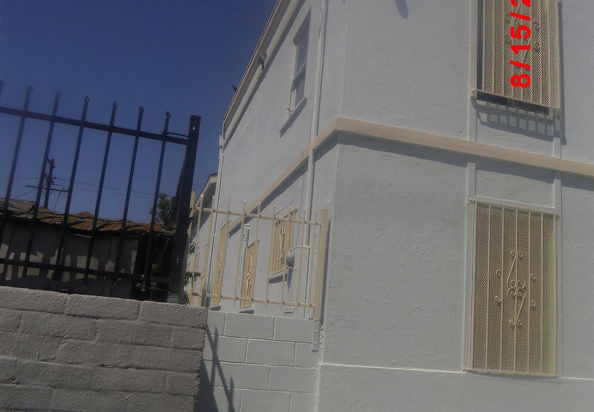 A white building with a fence and stairs in front of it