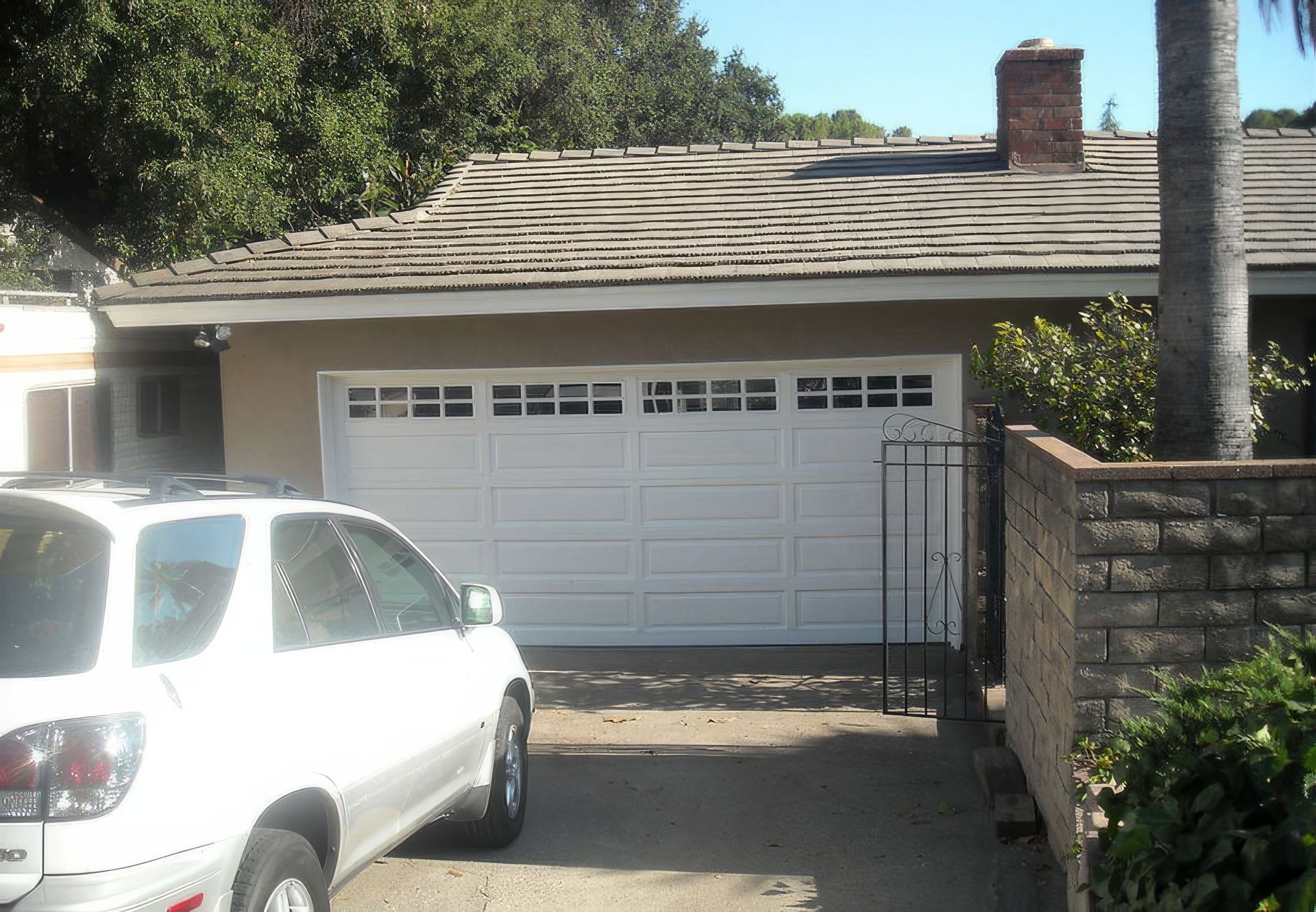 A white suv is parked in front of a white garage door