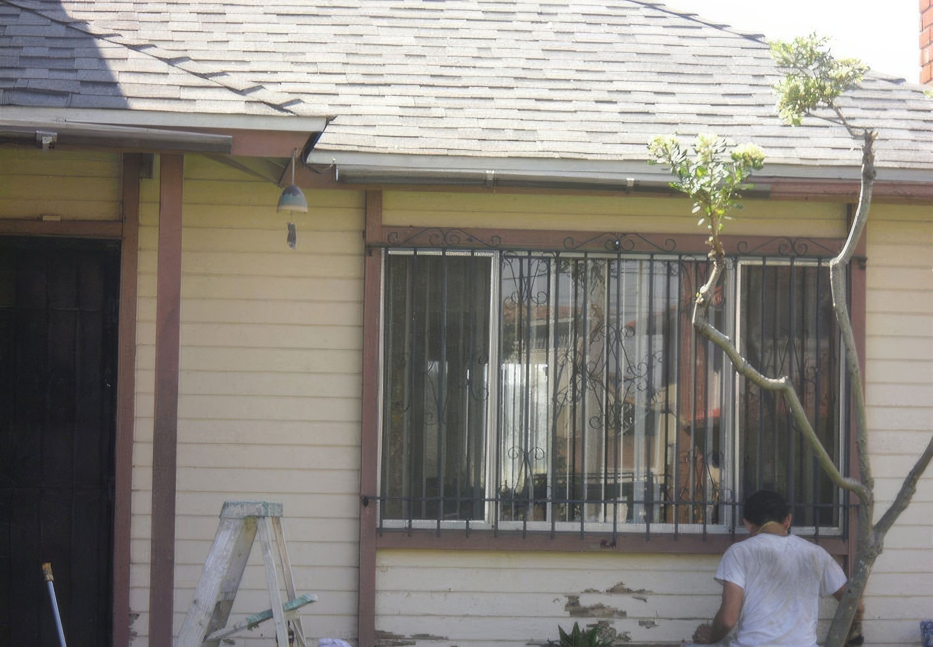 A man standing in front of a house with bars on the windows