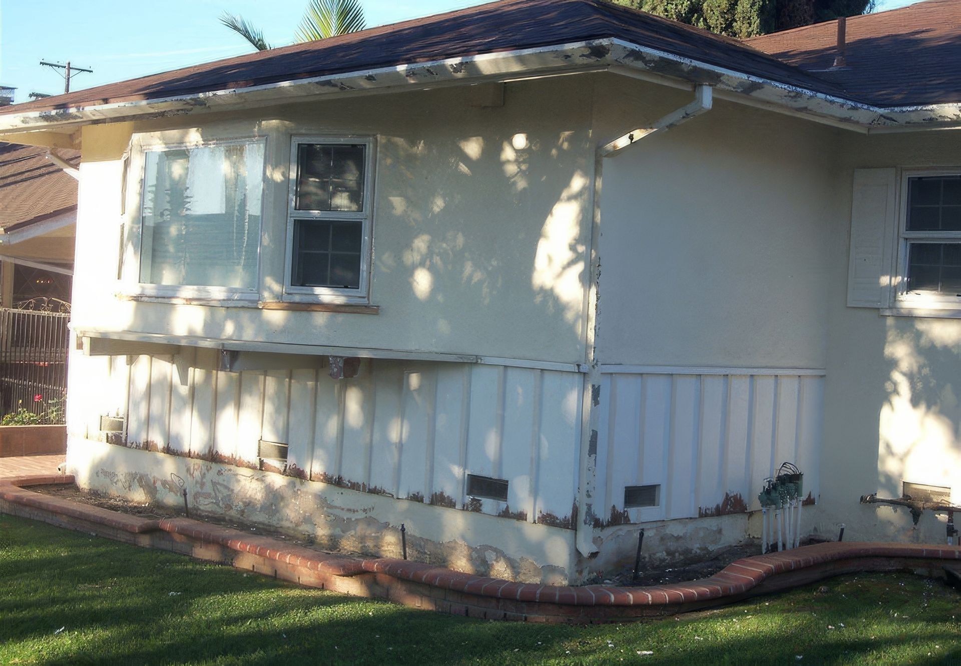 A white house with a brown roof and a lot of windows