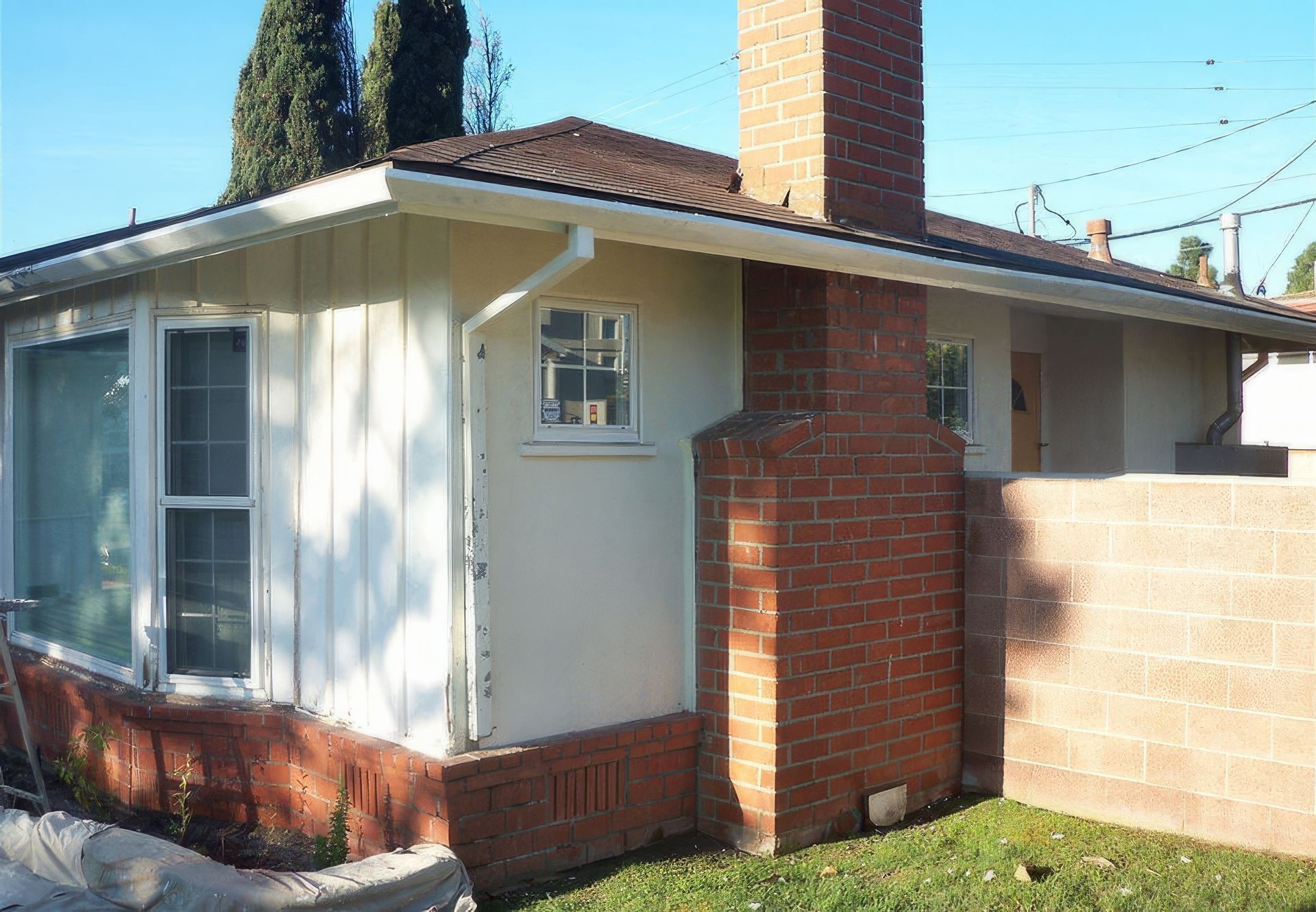 A small white house with a brick chimney