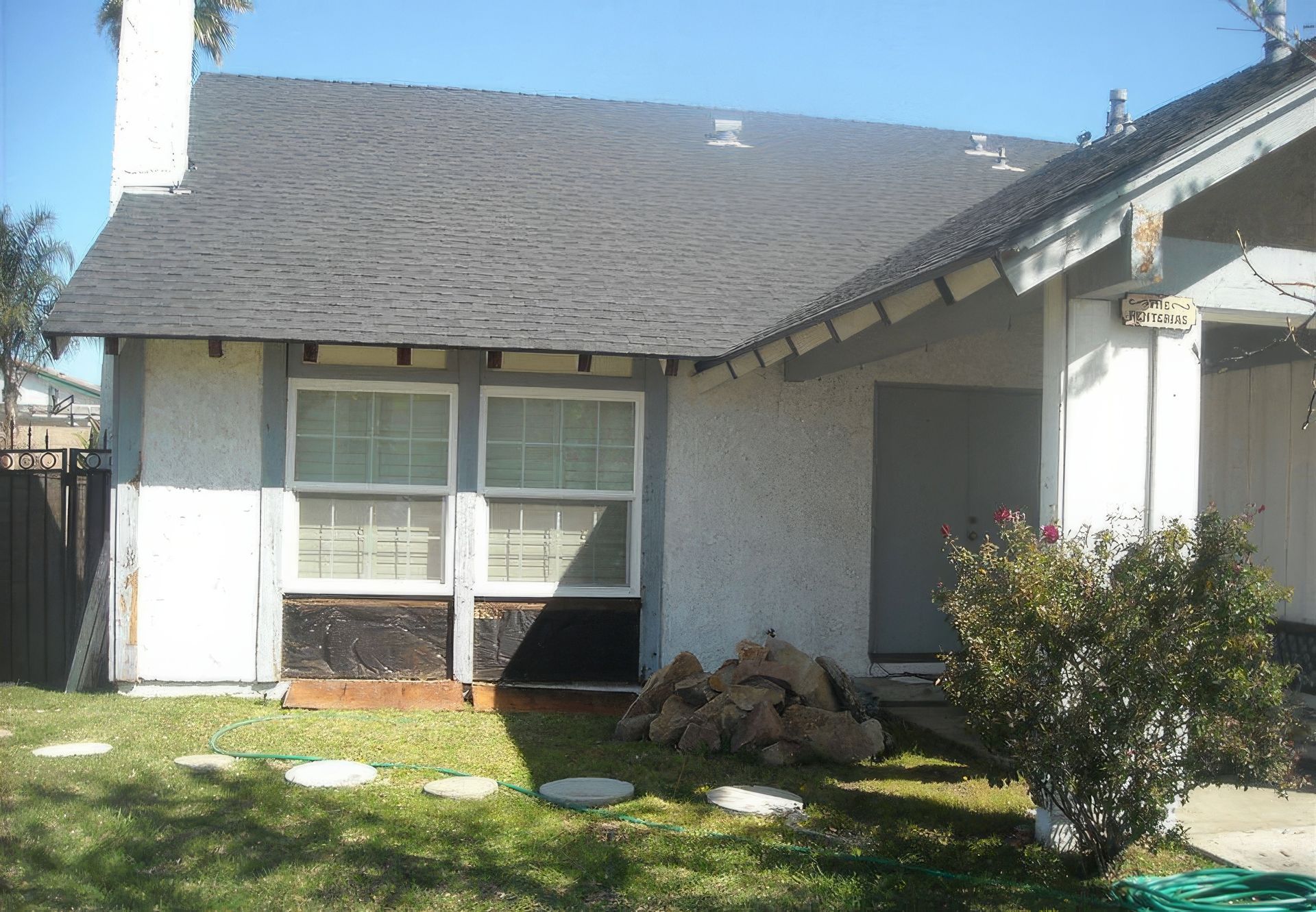 A white house with a gray roof and a chimney