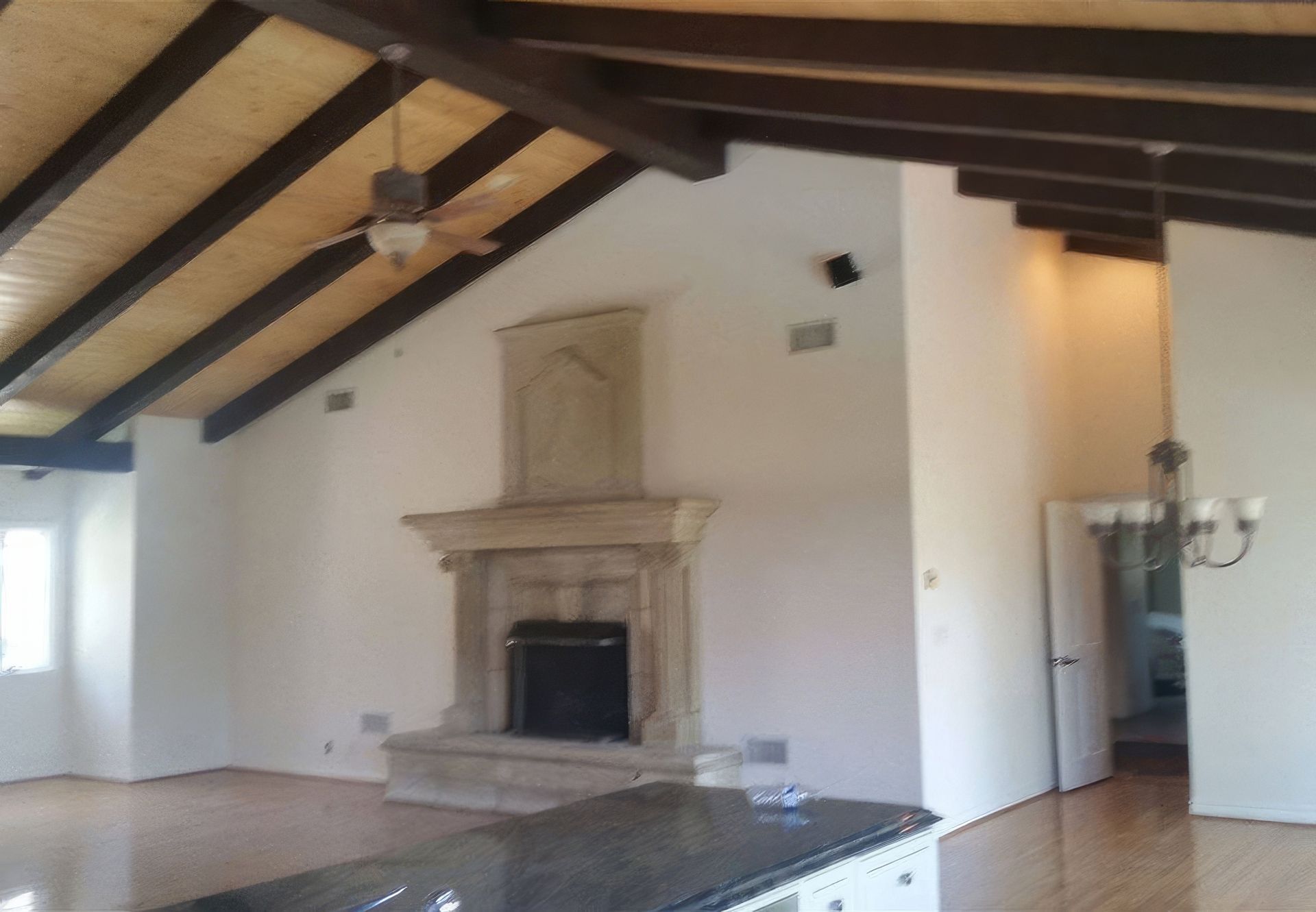 A living room with a fireplace and ceiling fan