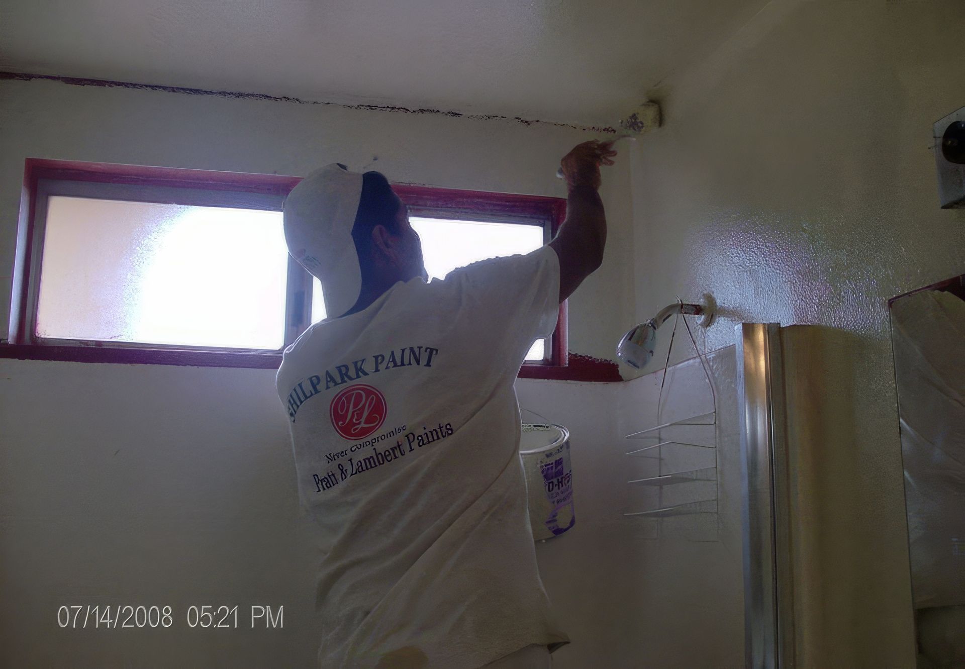 A man painting a wall with a shirt that says park paint