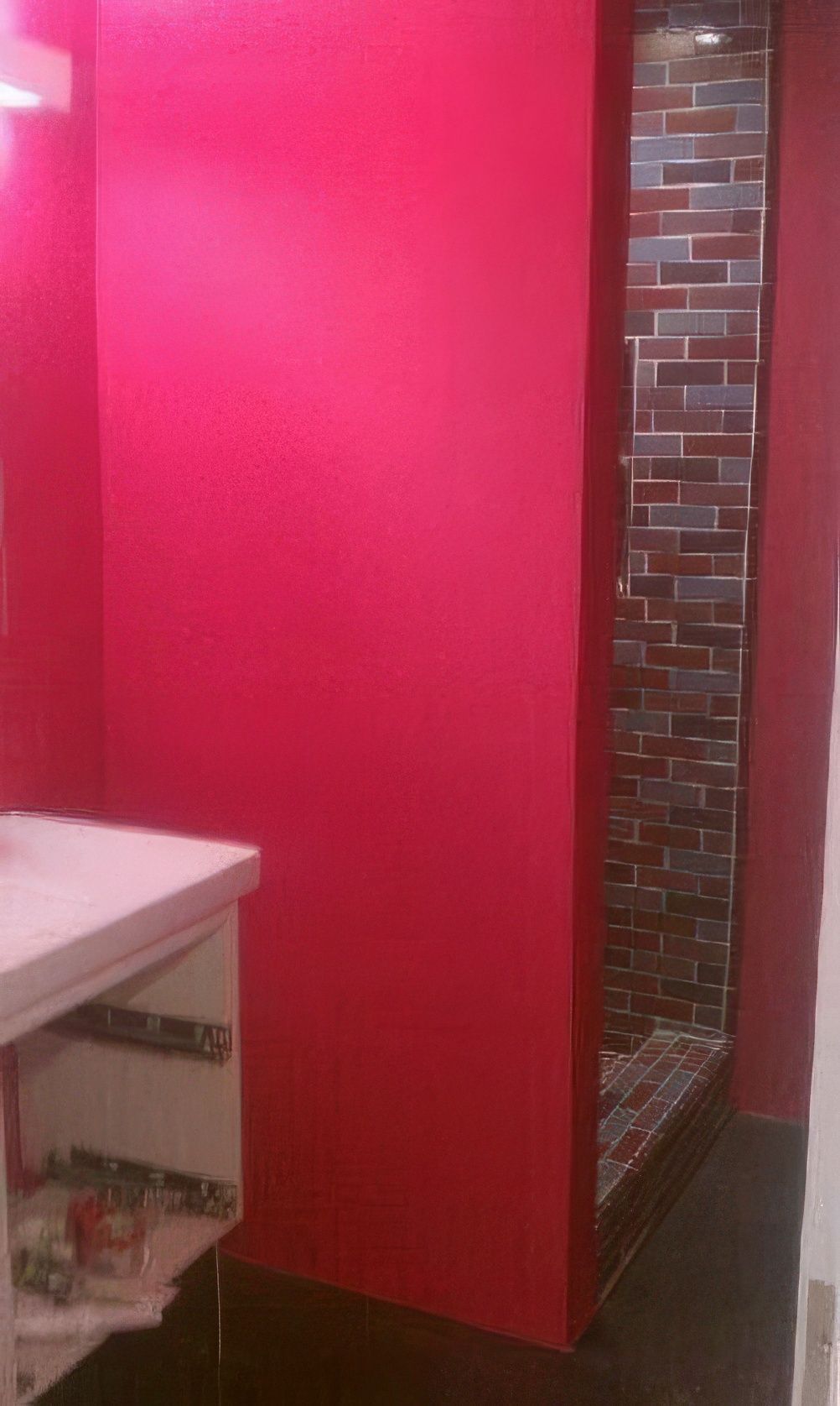 A bathroom with red walls and a walk in shower.