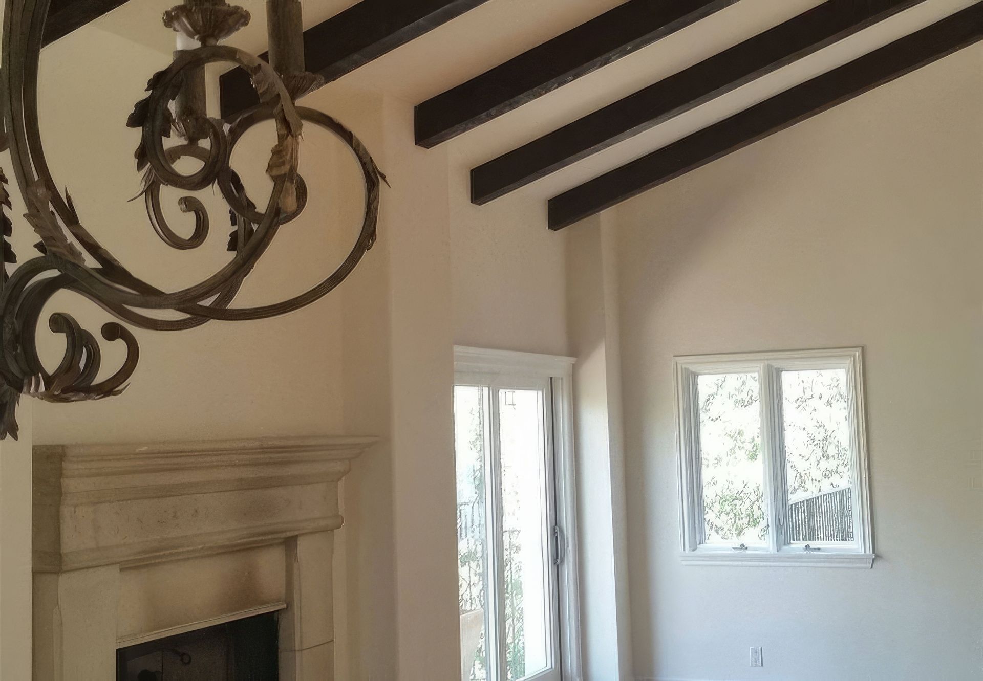 A living room with a fireplace and a chandelier hanging from the ceiling.