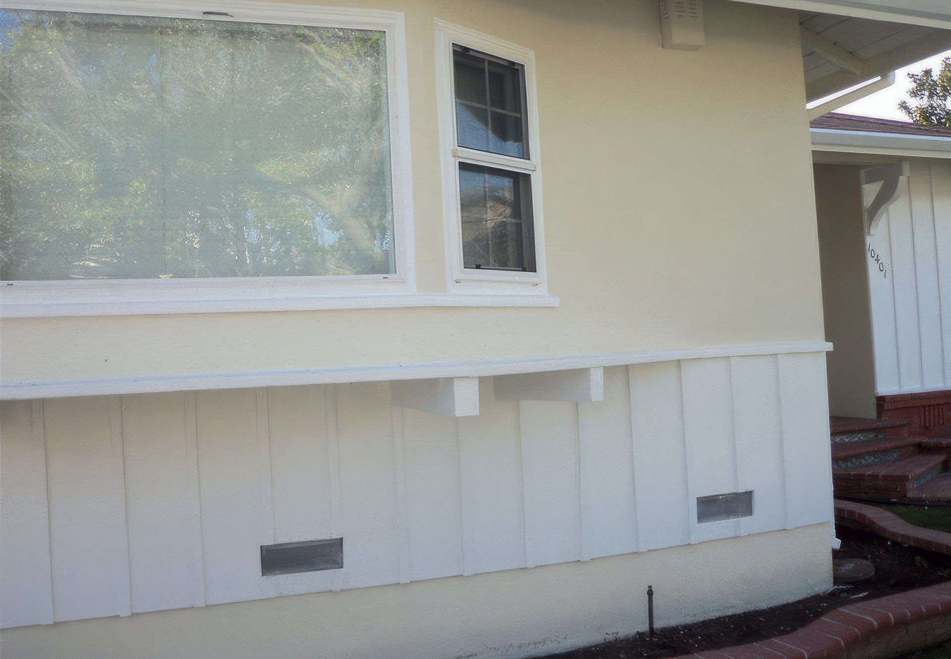 A white house with a window on the side of it