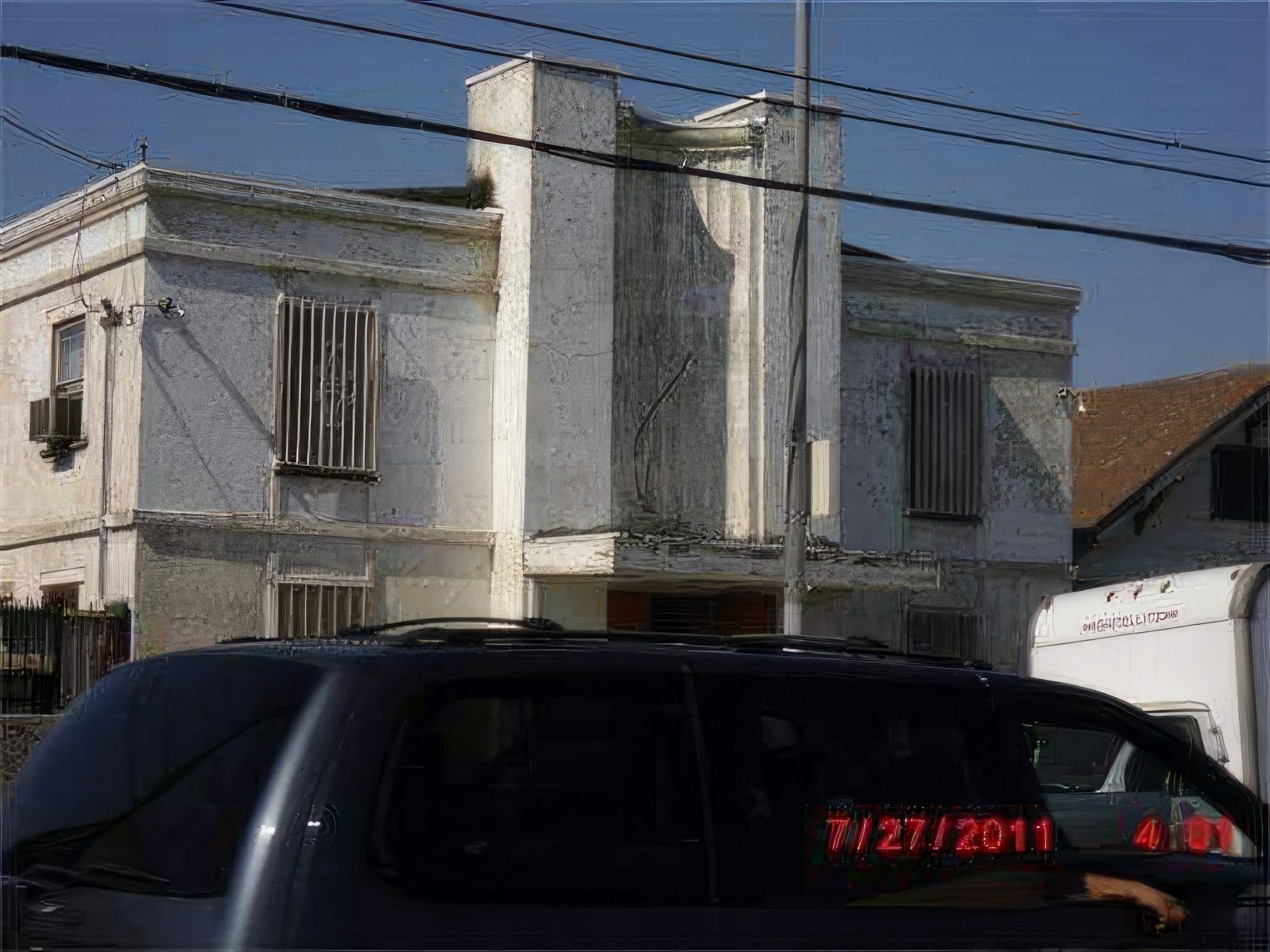A black suv is parked in front of a white building
