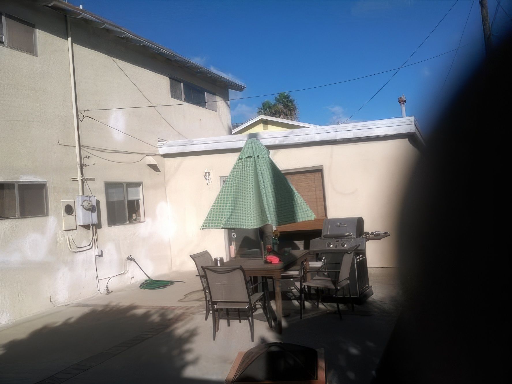 A backyard with a table and chairs and an umbrella
