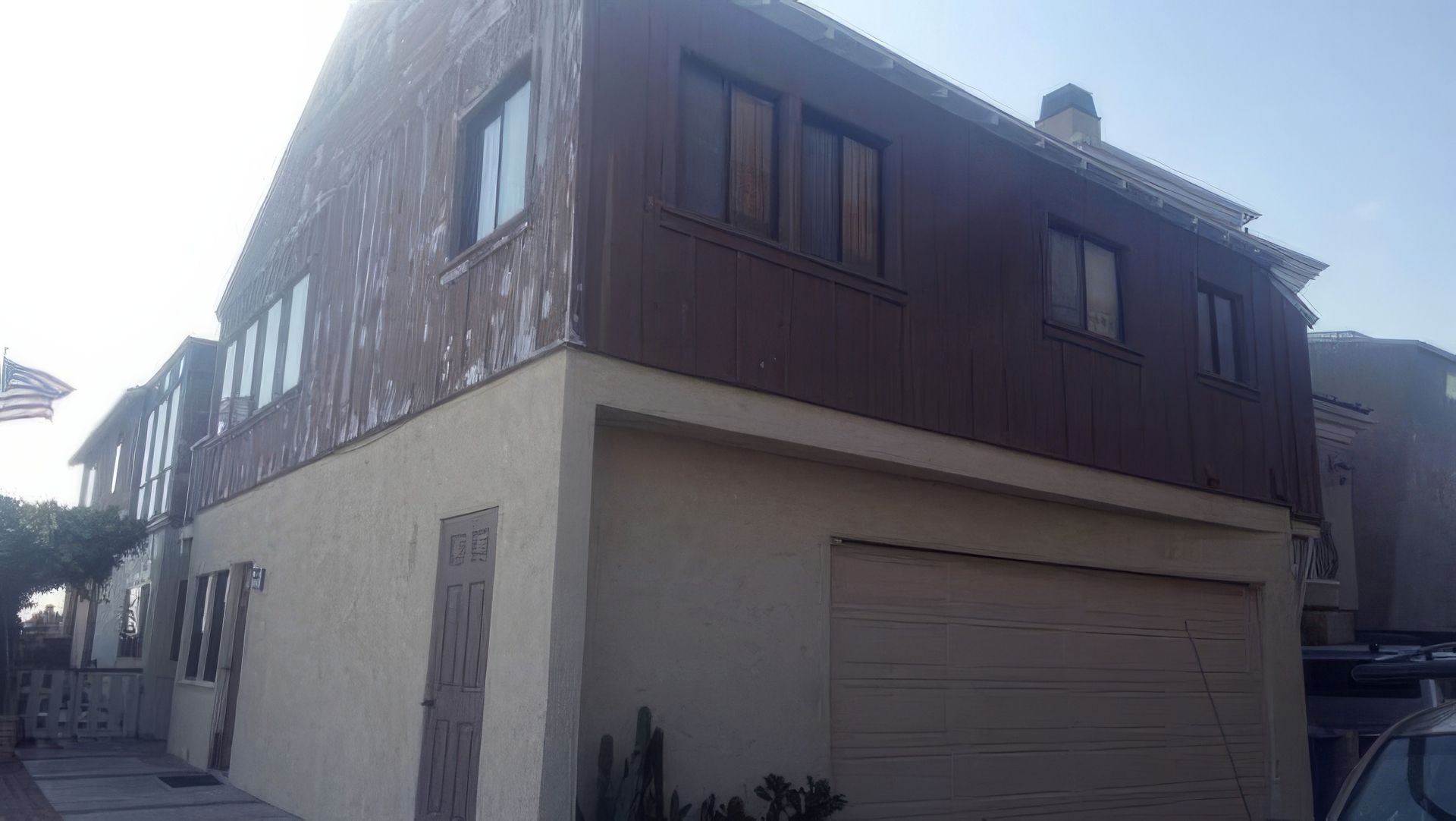 A large house with a garage and a car parked in front of it.