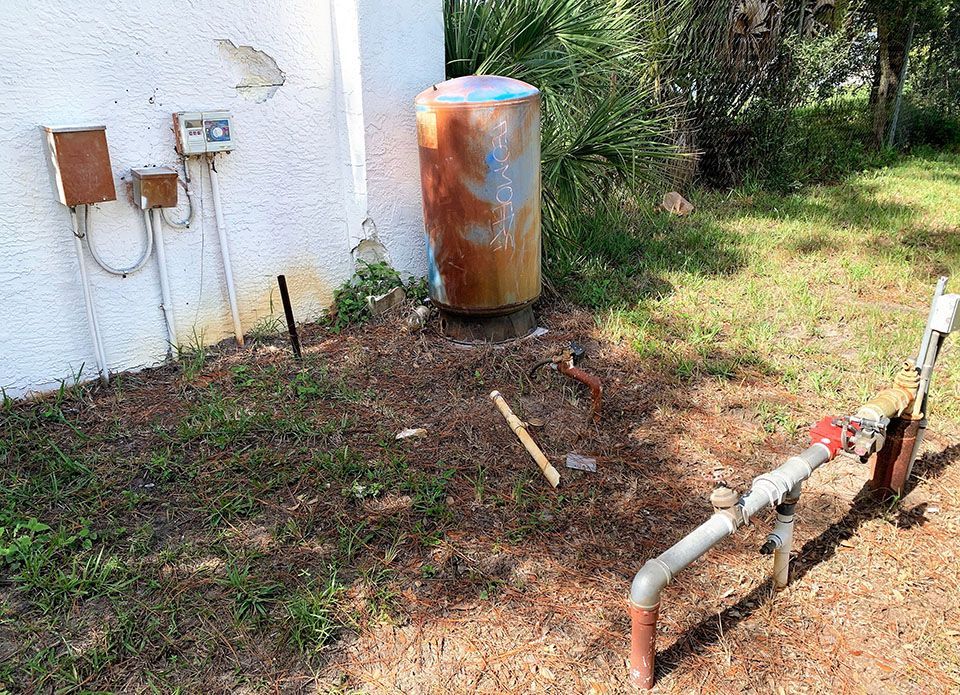 Rusted Tank next to building