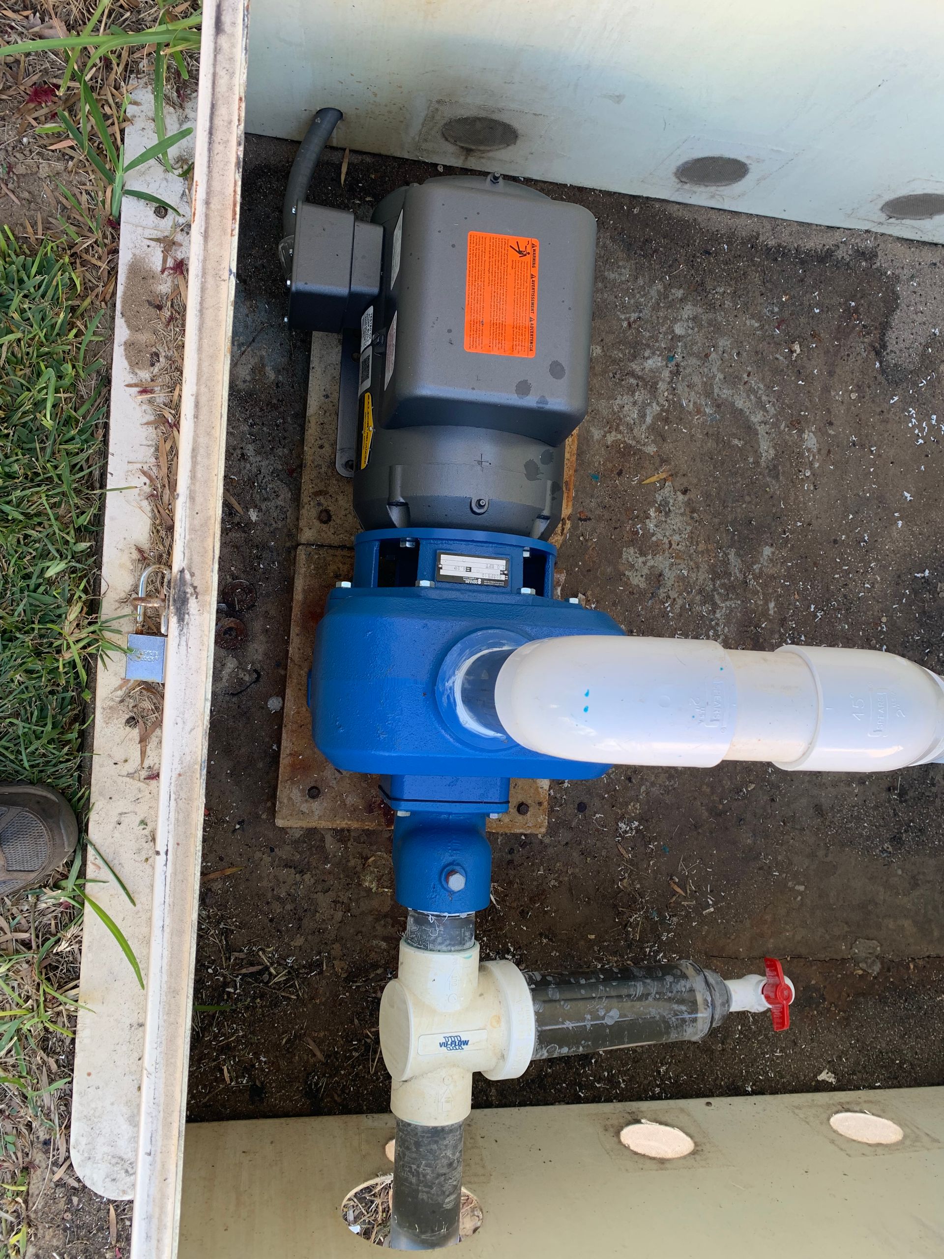 A blue pump is connected to a white pipe