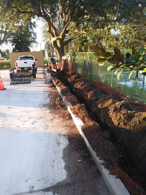 A trencher is digging a hole for new water line pipe