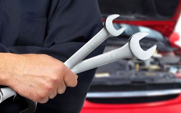 Mechanic holding car repair tools