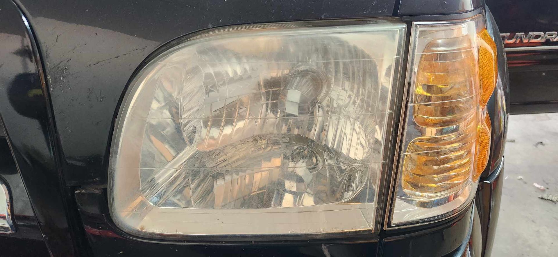 A close up of a black car 's headlight.